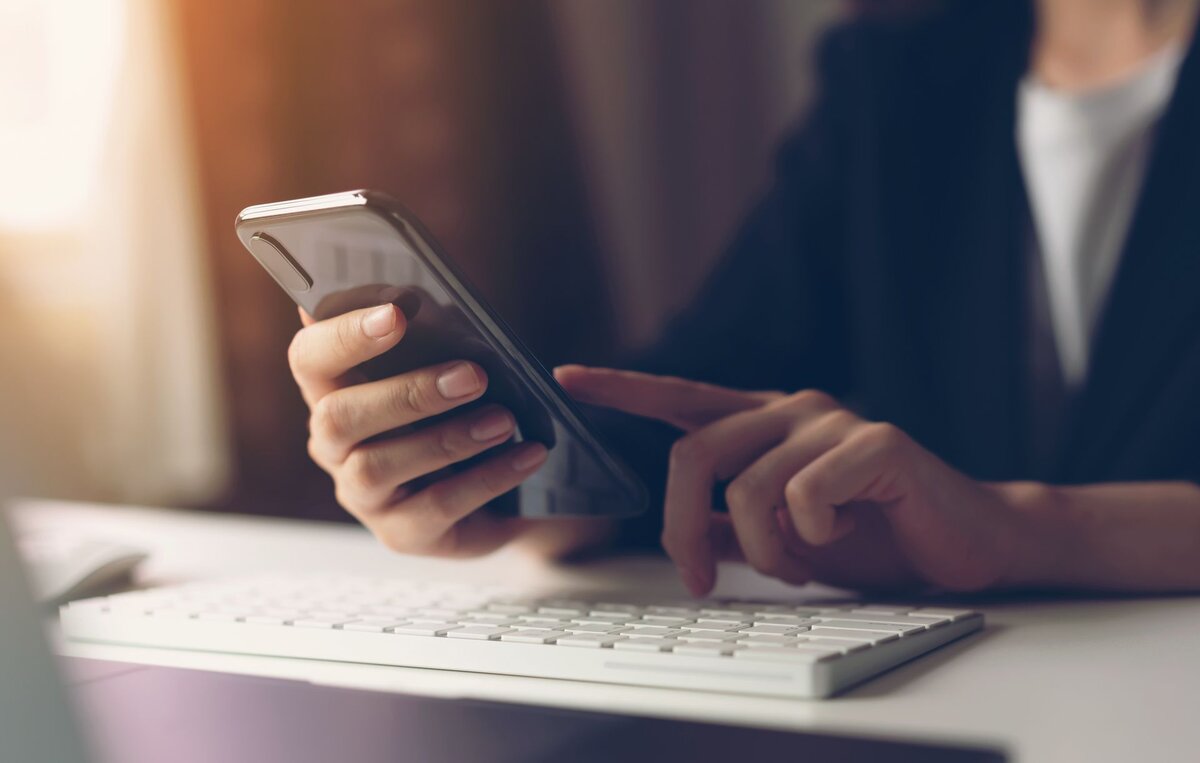 A hand holding a phone, booking an appointment