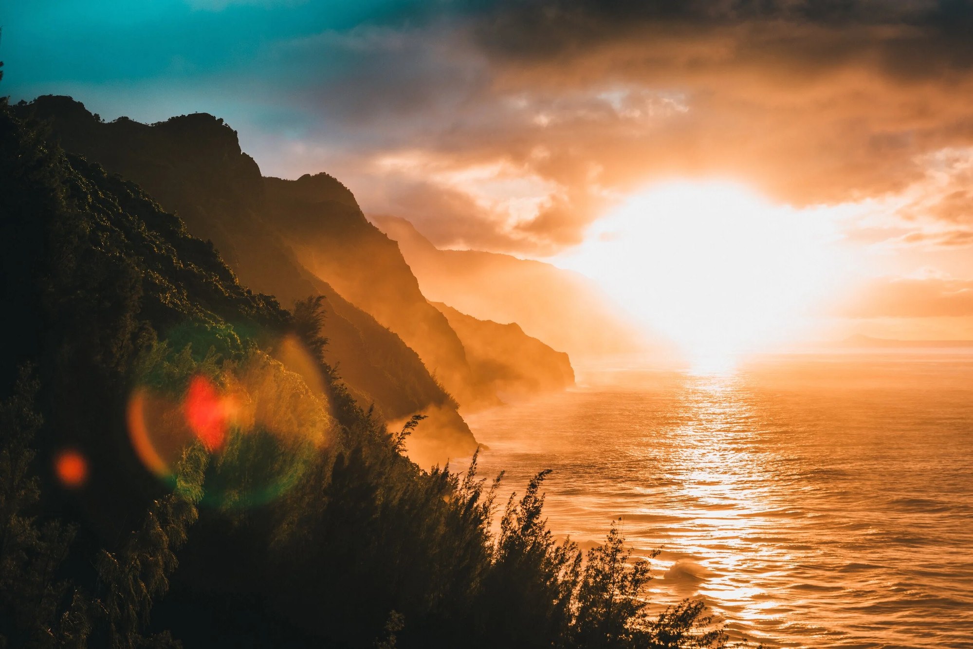 Sunlight breaking over a coastline at dawn