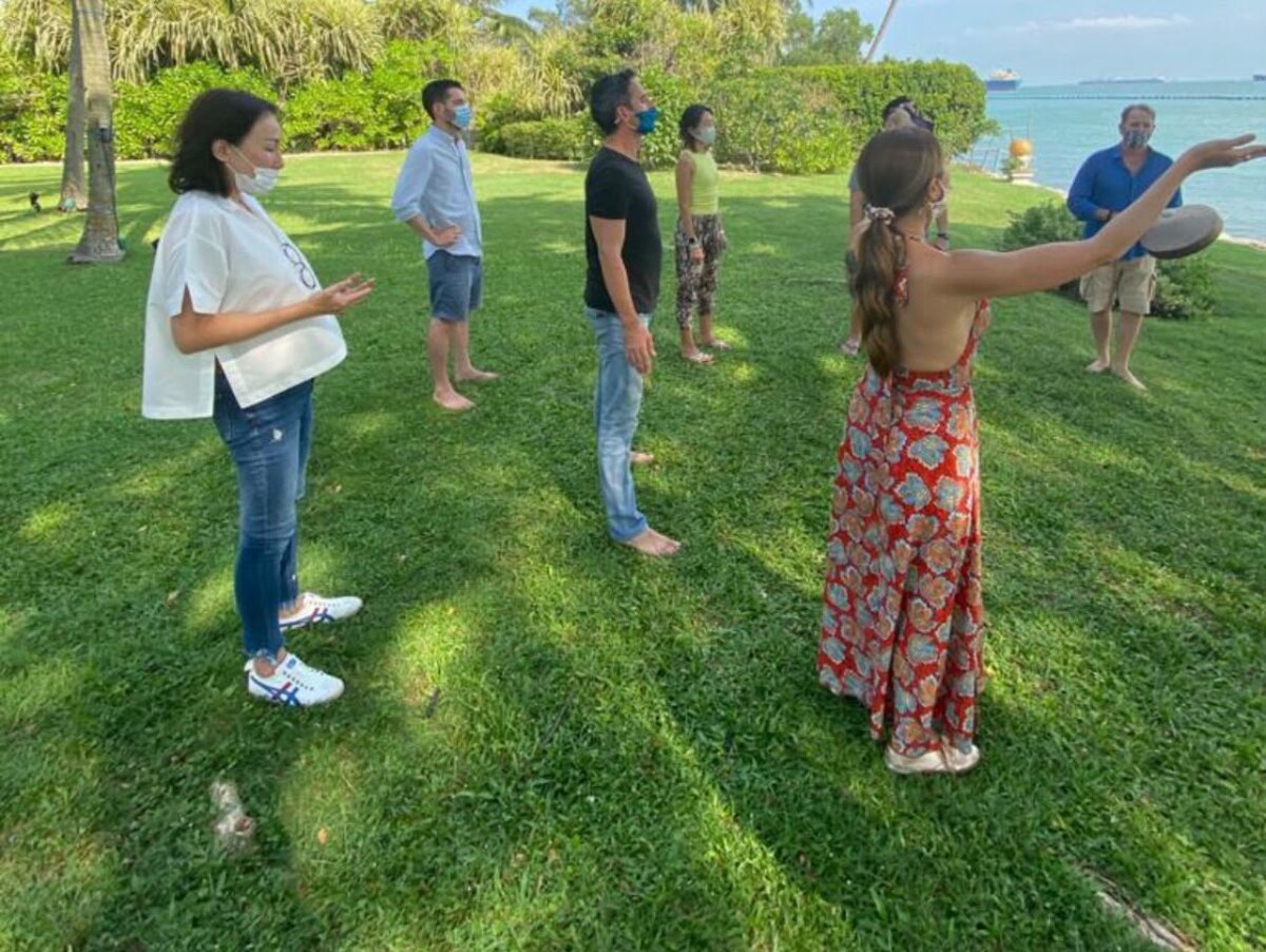 A grounding exercise on the lawn during a workshop by the sea